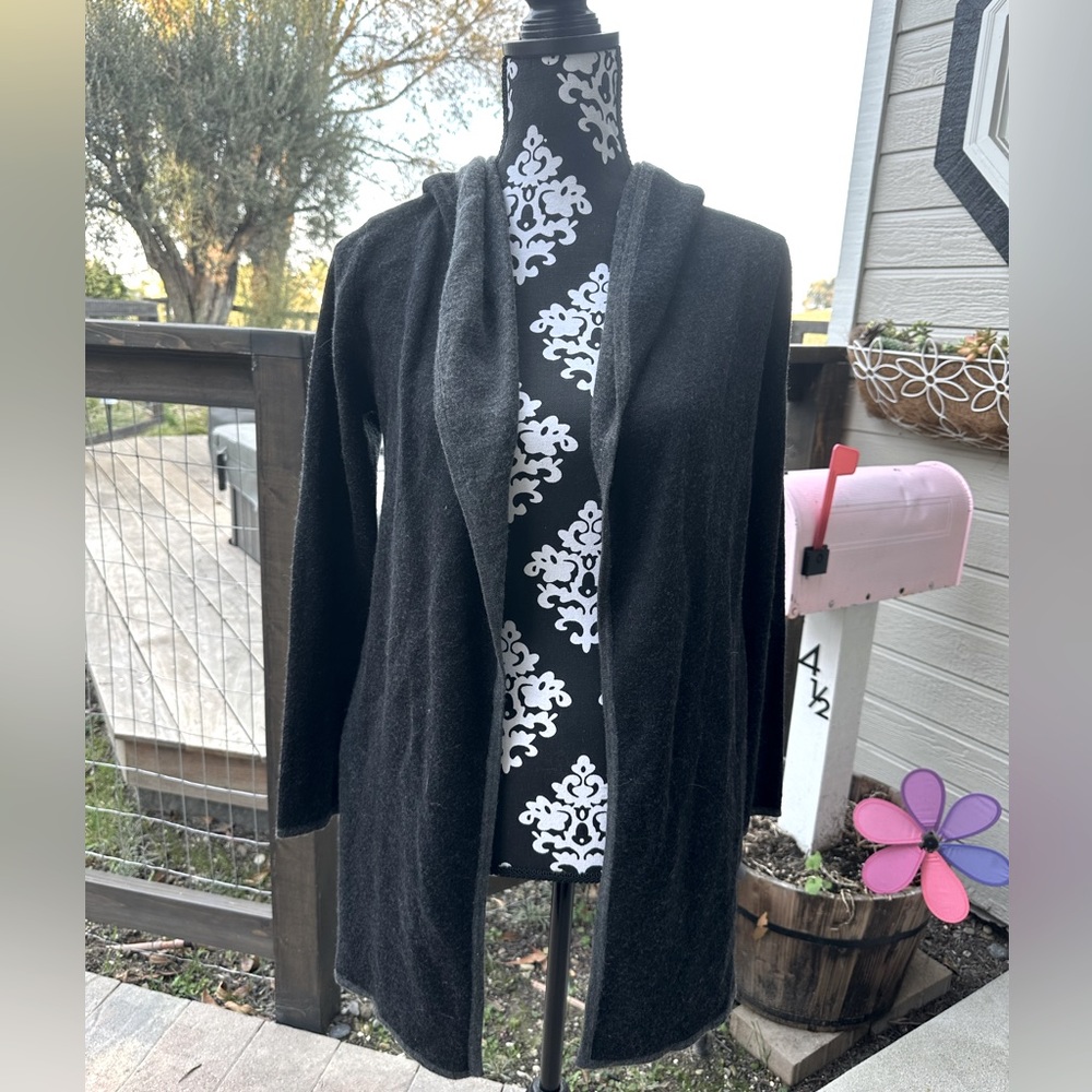 Cardigan/shrug style sweater. Black and grey with a hood.